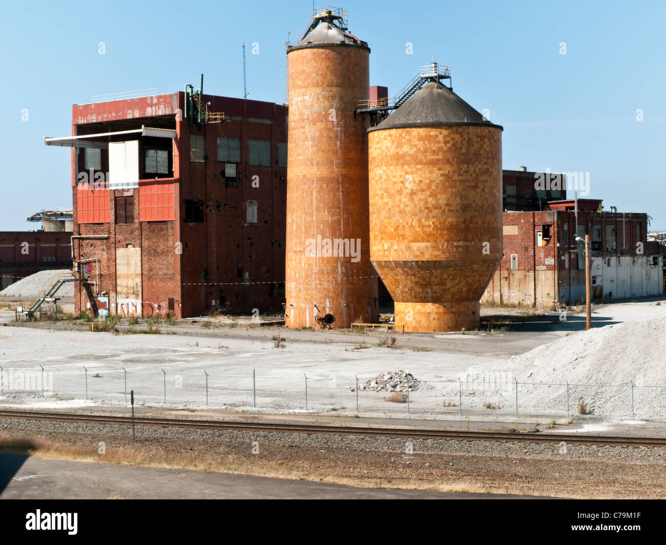 Formes industrielle forte de l'abandon des papiers avec des bâtiments en briques anciennes ensoleillée et silos contre ciel bleu pur Bellingham WA Banque D'Images