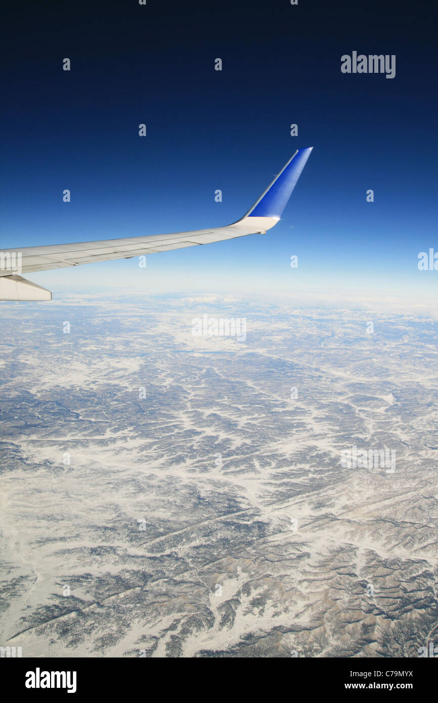 Vue depuis un avion survolant les montagnes d'hiver avec la compagnie aérienne visible d'aile Banque D'Images