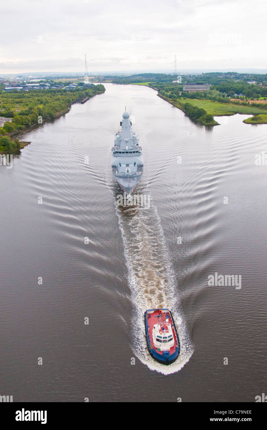 Bateau remorqueur escorte Battler HMS Dragon le long de la rivière Clyde avant la prise de possession de la Royal Navy à Portsmouth. Banque D'Images