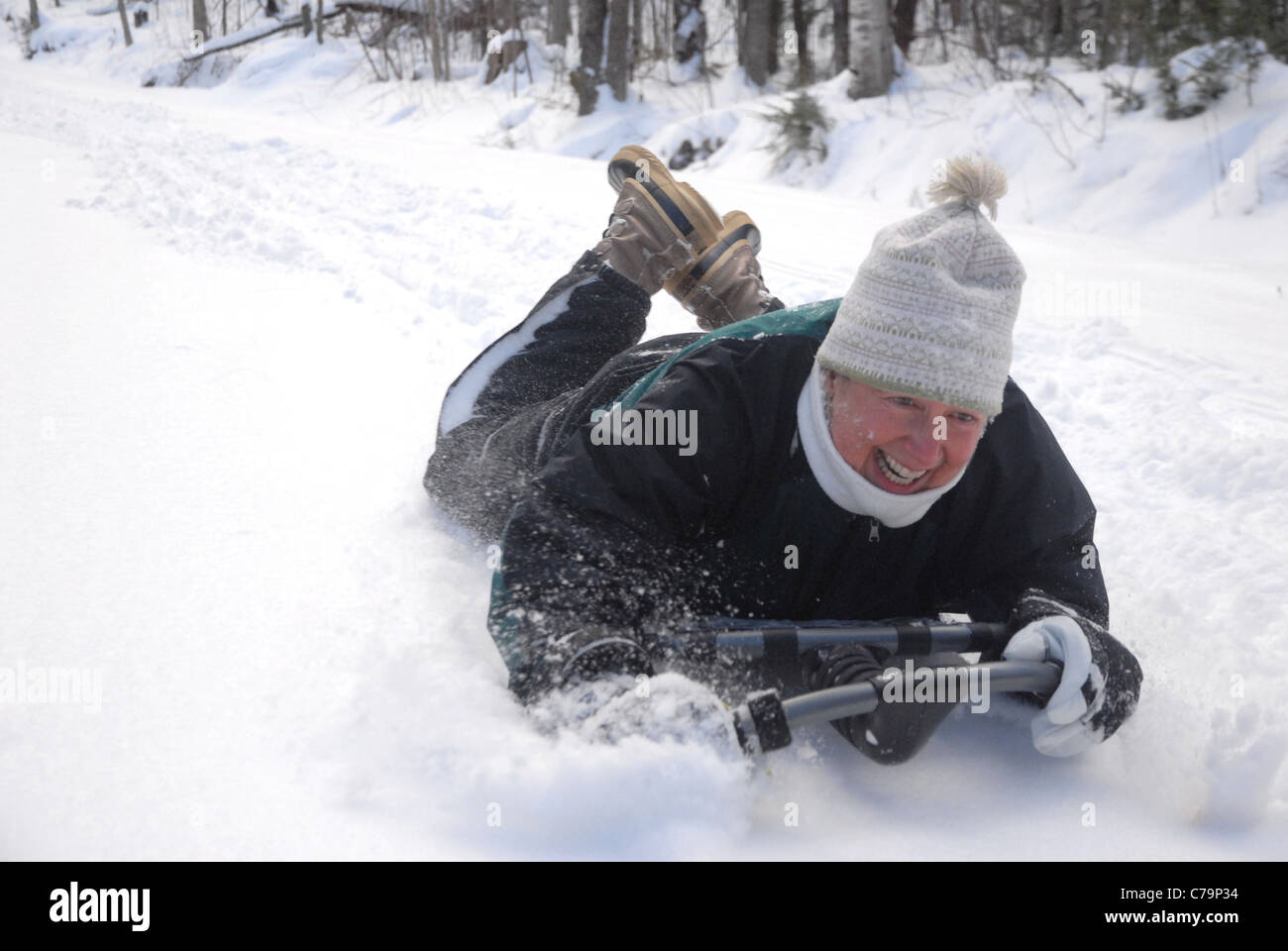 Traîneaux d'une femme sur une colline comme elle aime l'hiver dans le Vermont. Banque D'Images