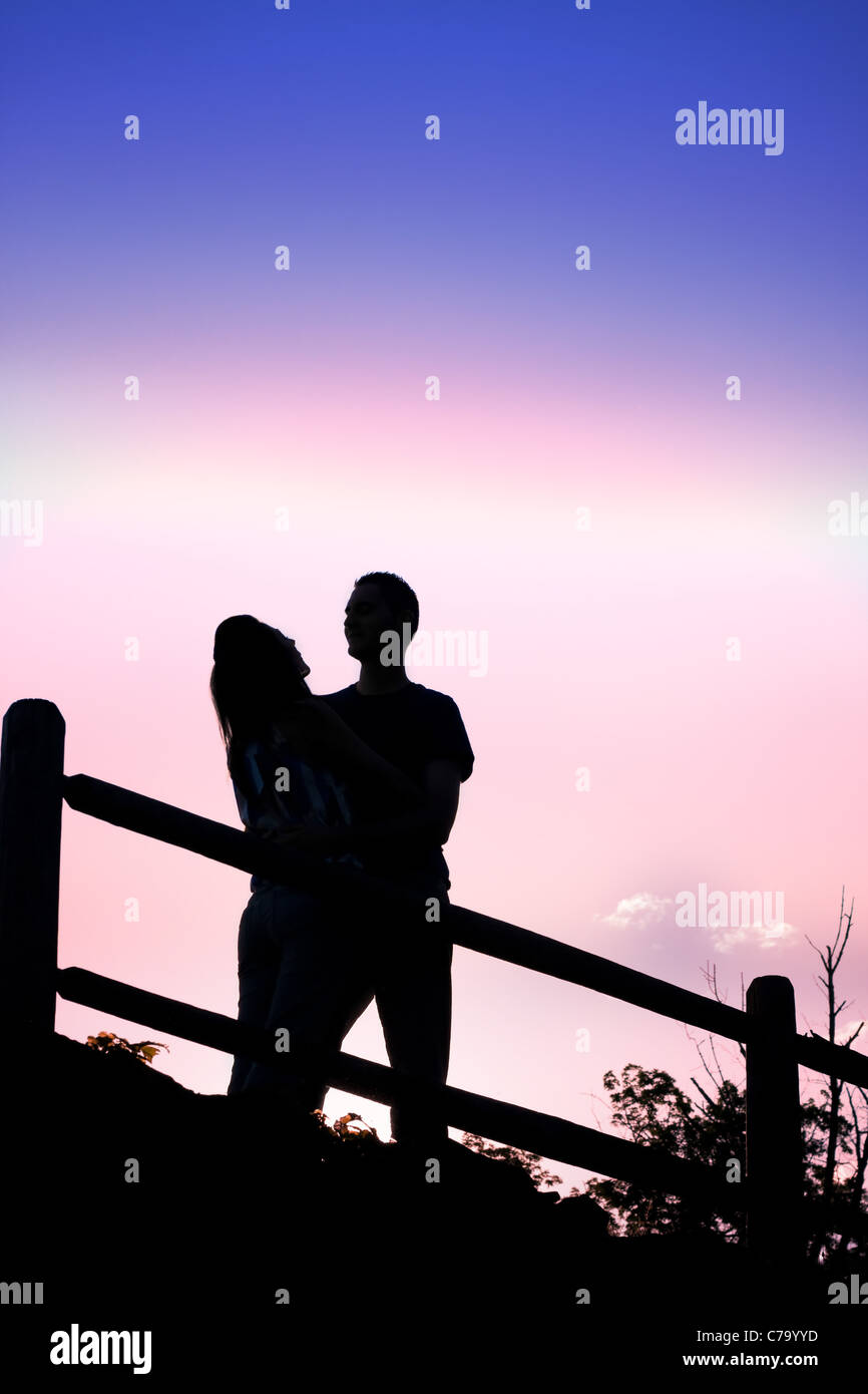 Silhouette d'une affectueuse romantique couple qui s'embrassent en début de soirée. Banque D'Images