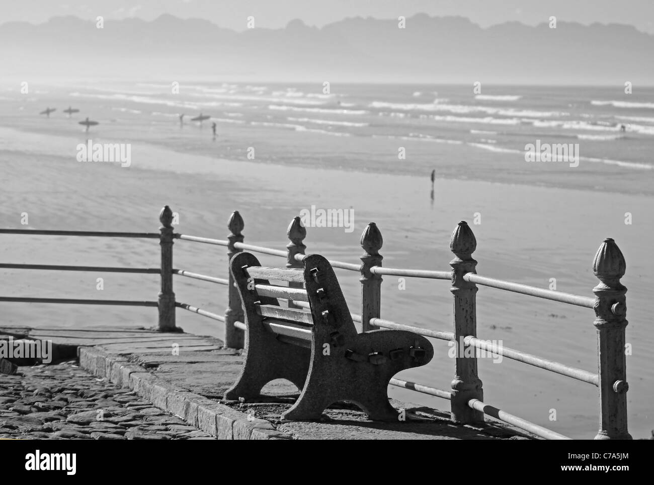 Banc avec vue sur surfer's Corner à Muizenberg. (Noir et blanc). Banque D'Images