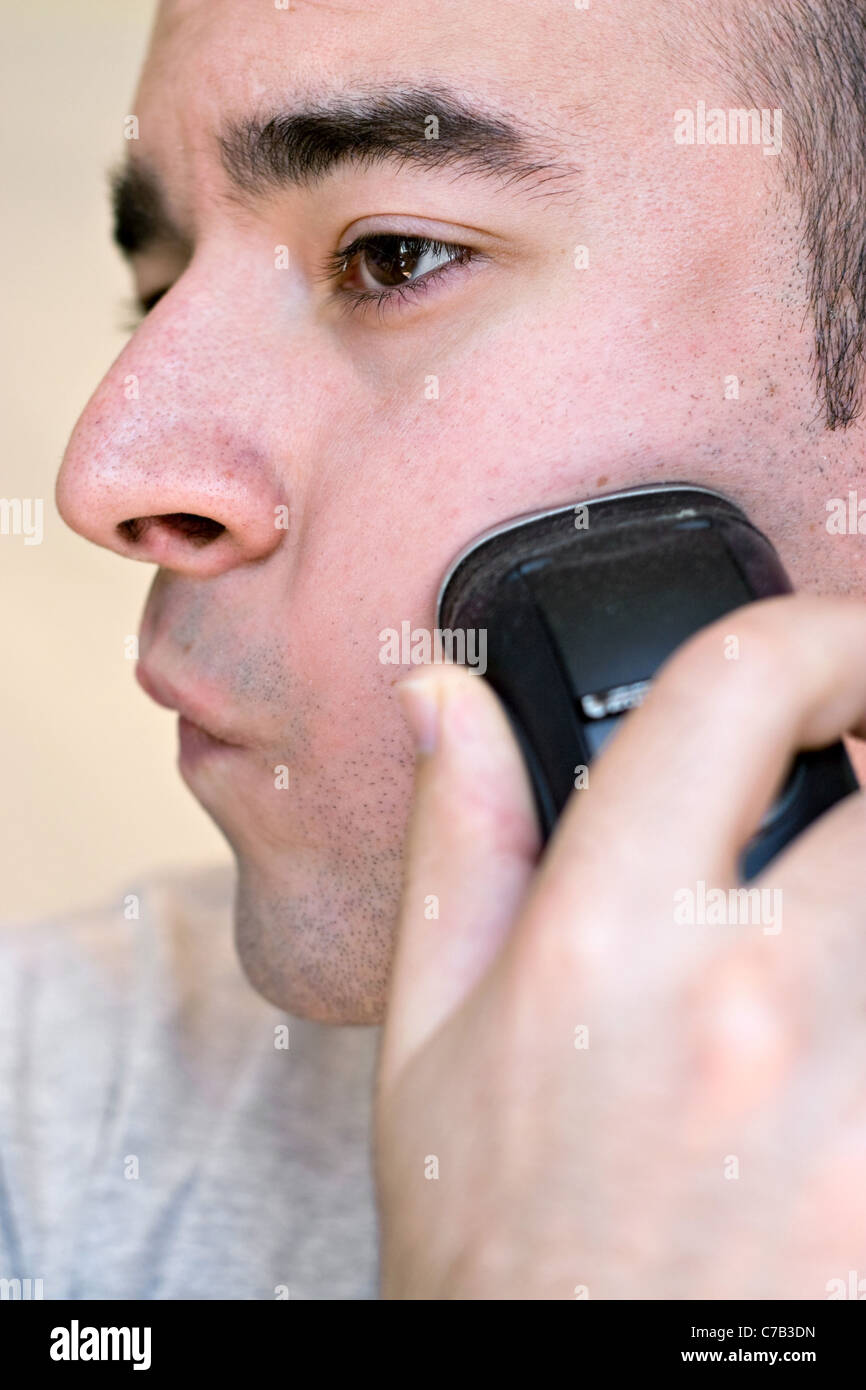 Un gros plan d'un jeune homme se raser la barbe avec un rasoir électrique  en noir et blanc Photo Stock - Alamy