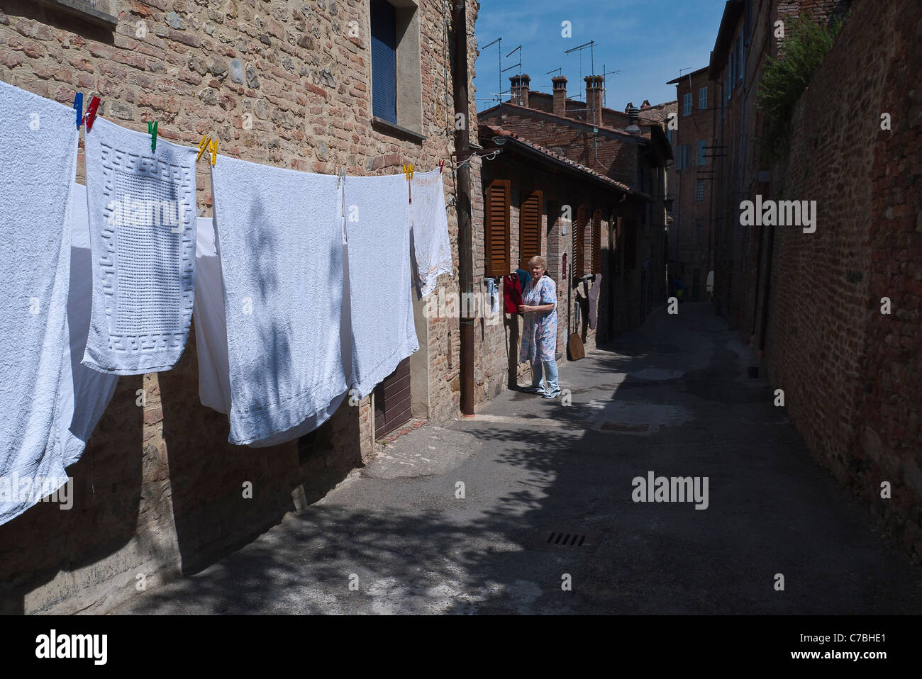 Blanchisserie soit accroché à sécher sur une corde à linge accroché sur une étroite rue médiévale de la ville de Citta della Pieve, Ombrie, Italie. Banque D'Images