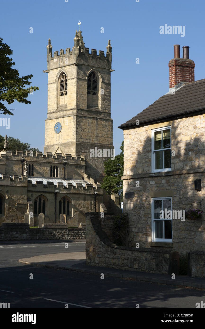 400 ans ferme en pierre calcaire avec l'église St Pierre en arrière-plan, Barnburgh, Yorkshire, Angleterre. Banque D'Images