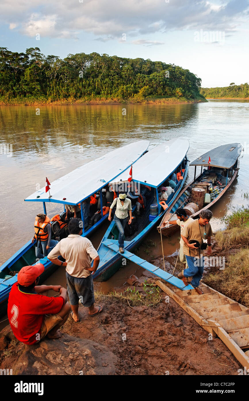 Les touristes débarquant d'excursion en bateau sur la rivière Tambopata, Pérou Banque D'Images