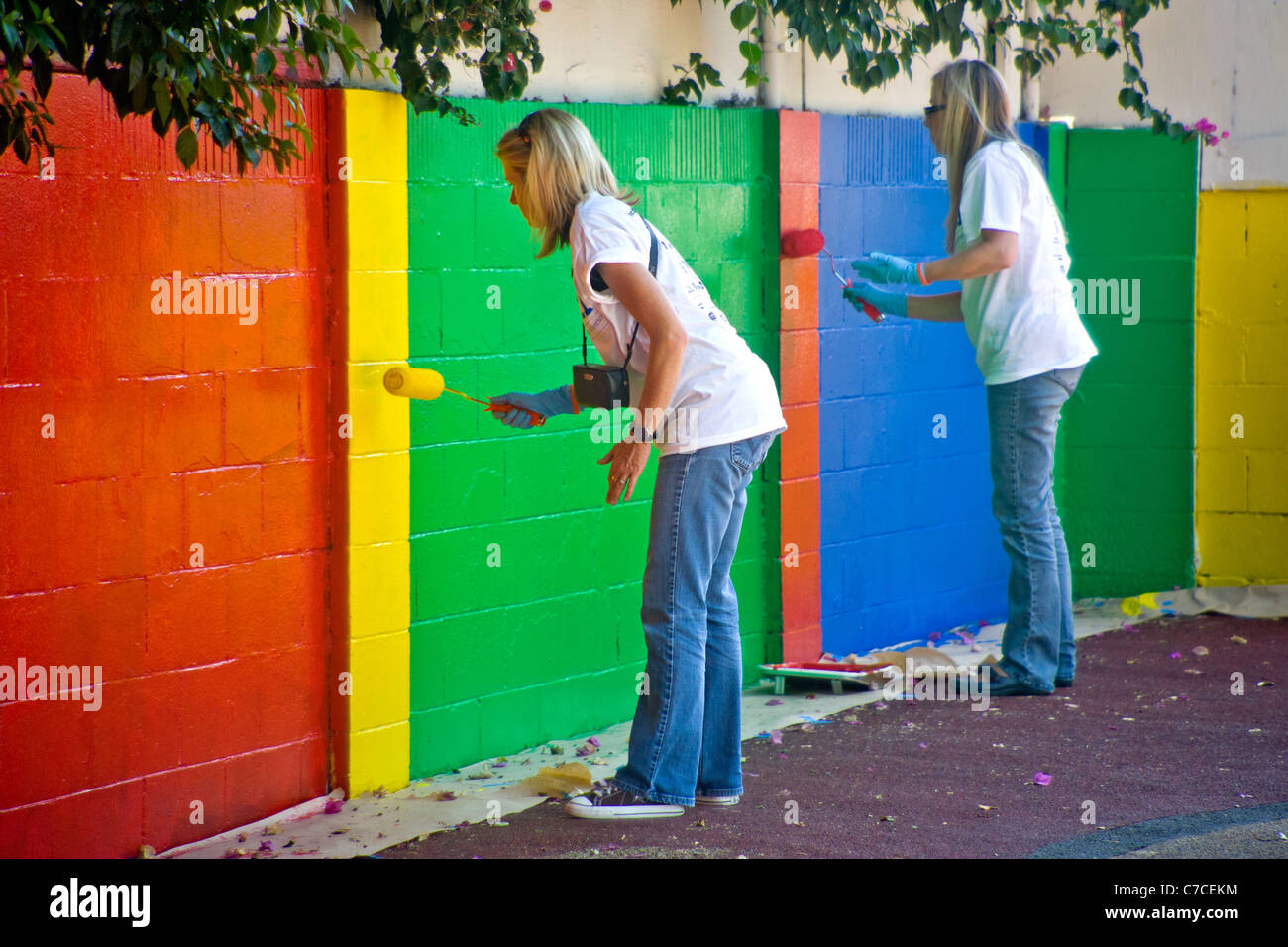 Décorations peinture bénévoles dans une ville de jeux au cours d'un programme d'embellissement de la collectivité à Santa Ana, CA. Banque D'Images