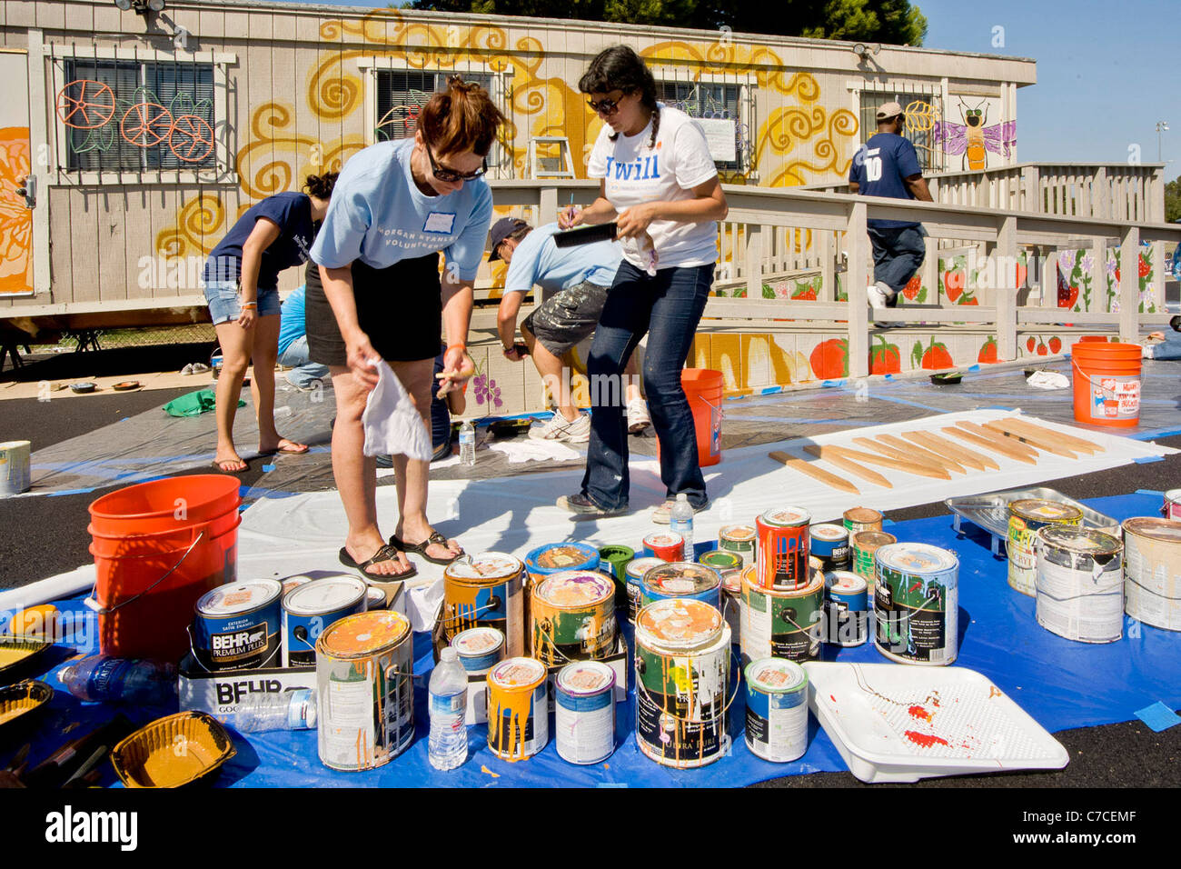 Volontaires dans logo T-shirts mélanger la peinture à un projet d'embellissement de la communauté à Santa Ana, CA. Banque D'Images