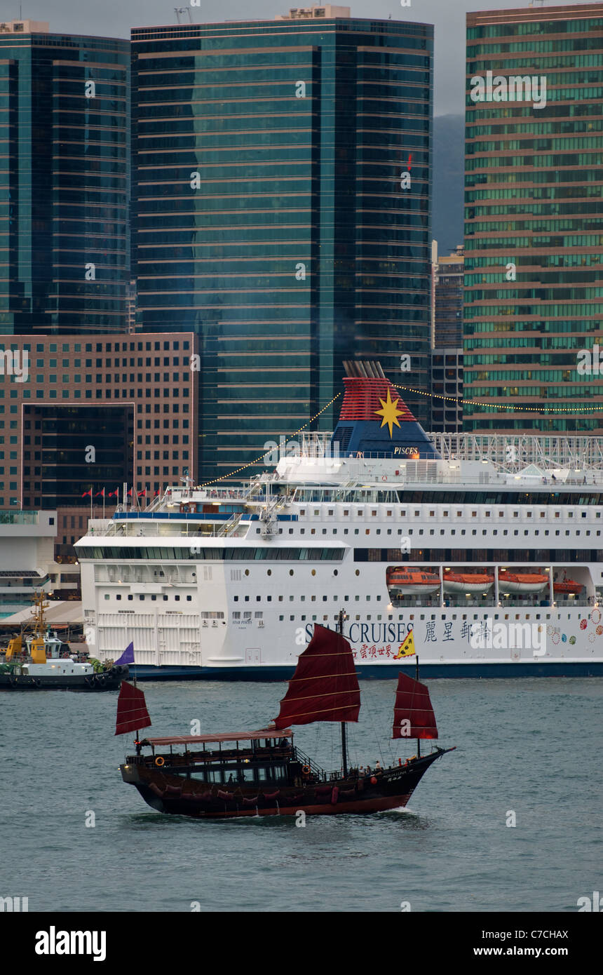 L'Aqua Luna junk sails passé un grand bateau de croisière dans le port de Victoria. Banque D'Images
