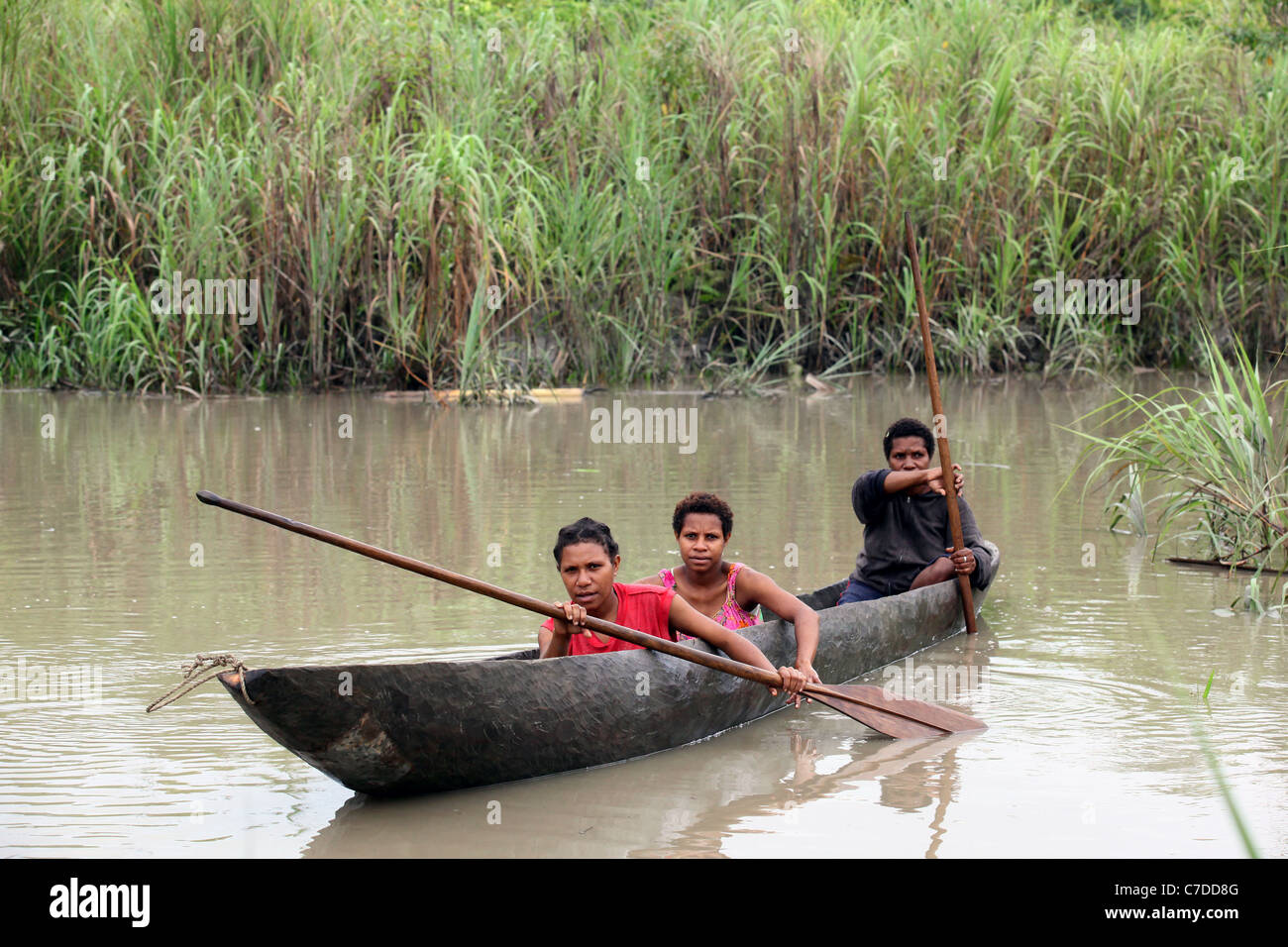 Trois jeunes filles dans une pirogue sur un fleuve en Papouasie Nouvelle Guinée Banque D'Images