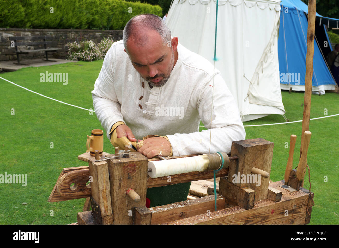 L'homme qui démontre la méthode traditionnelle de la sculpture bois à l'aide d'une dérouleuse actionnée au pied, Kilmarnock, Ayrshire, Scotland, UK Banque D'Images