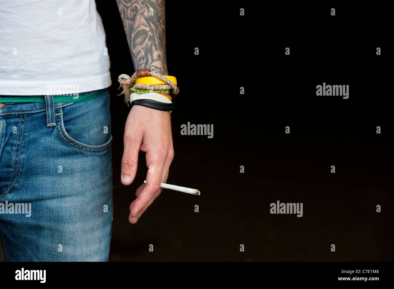 L'adolescent tatoué tenant un joint de cannabis Banque D'Images