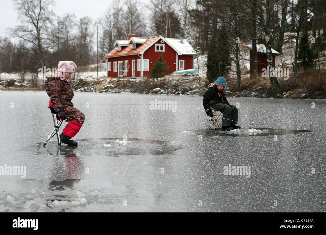 Les enfants pêche sur glace dans le lac Stora Bellen, Belloe, Suède Banque D'Images