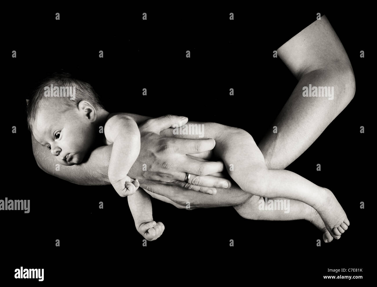 Sur les bras du nourrisson pères isolés sur noir Banque D'Images