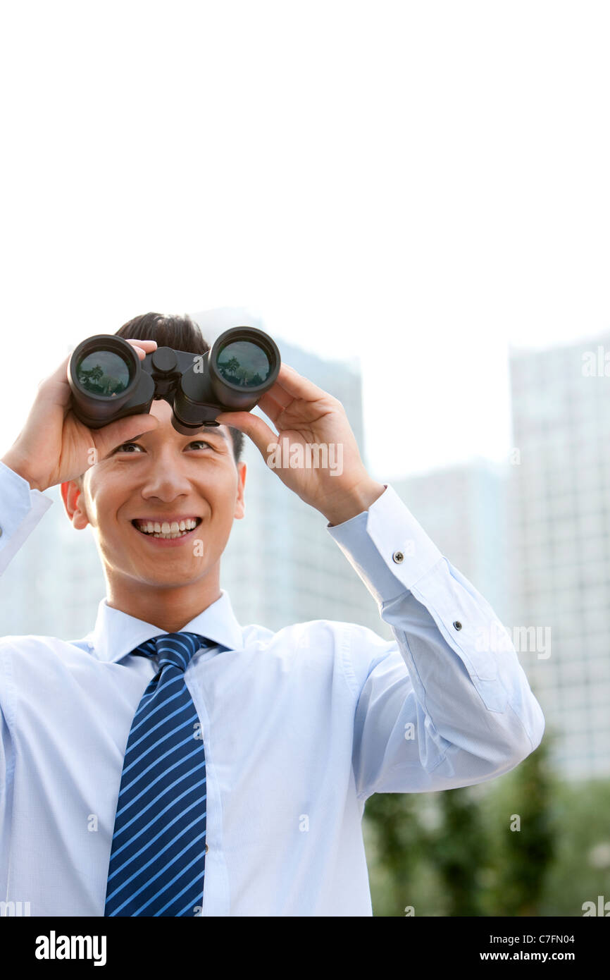 Businessman Looking through Binoculars Banque D'Images