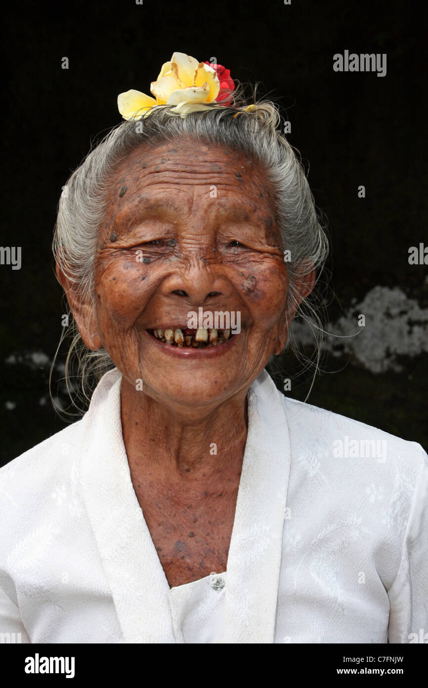 Smiling' ou 'Pemangku sainte femme qui veille sur les sculptures sur roc à Yeh Pulu Banque D'Images
