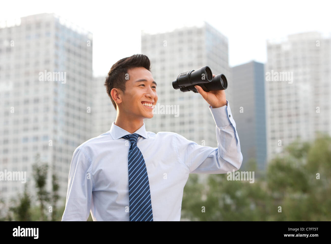 Businessman Looking through Binoculars Banque D'Images