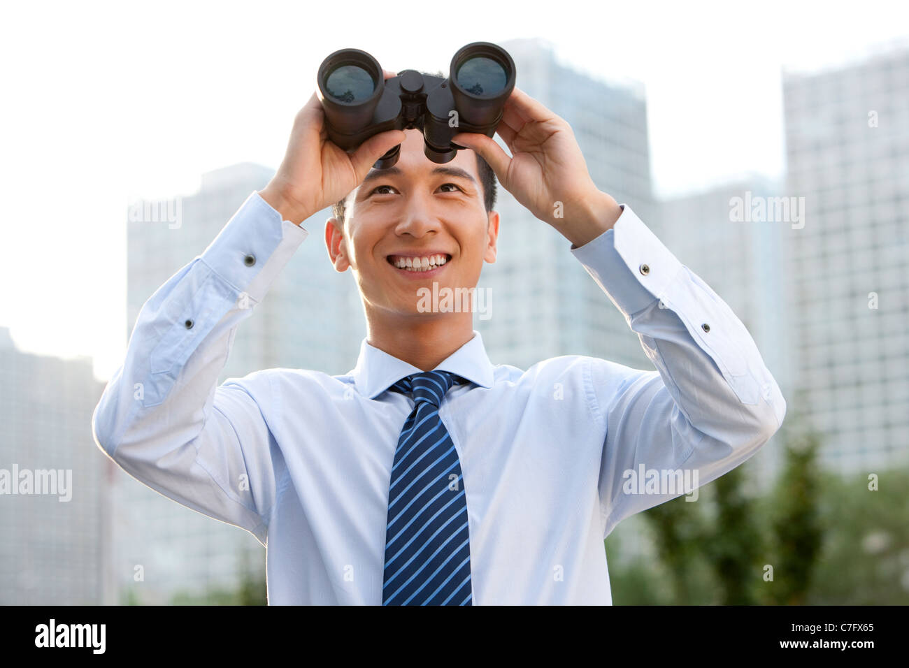 Businessman Looking through Binoculars Banque D'Images