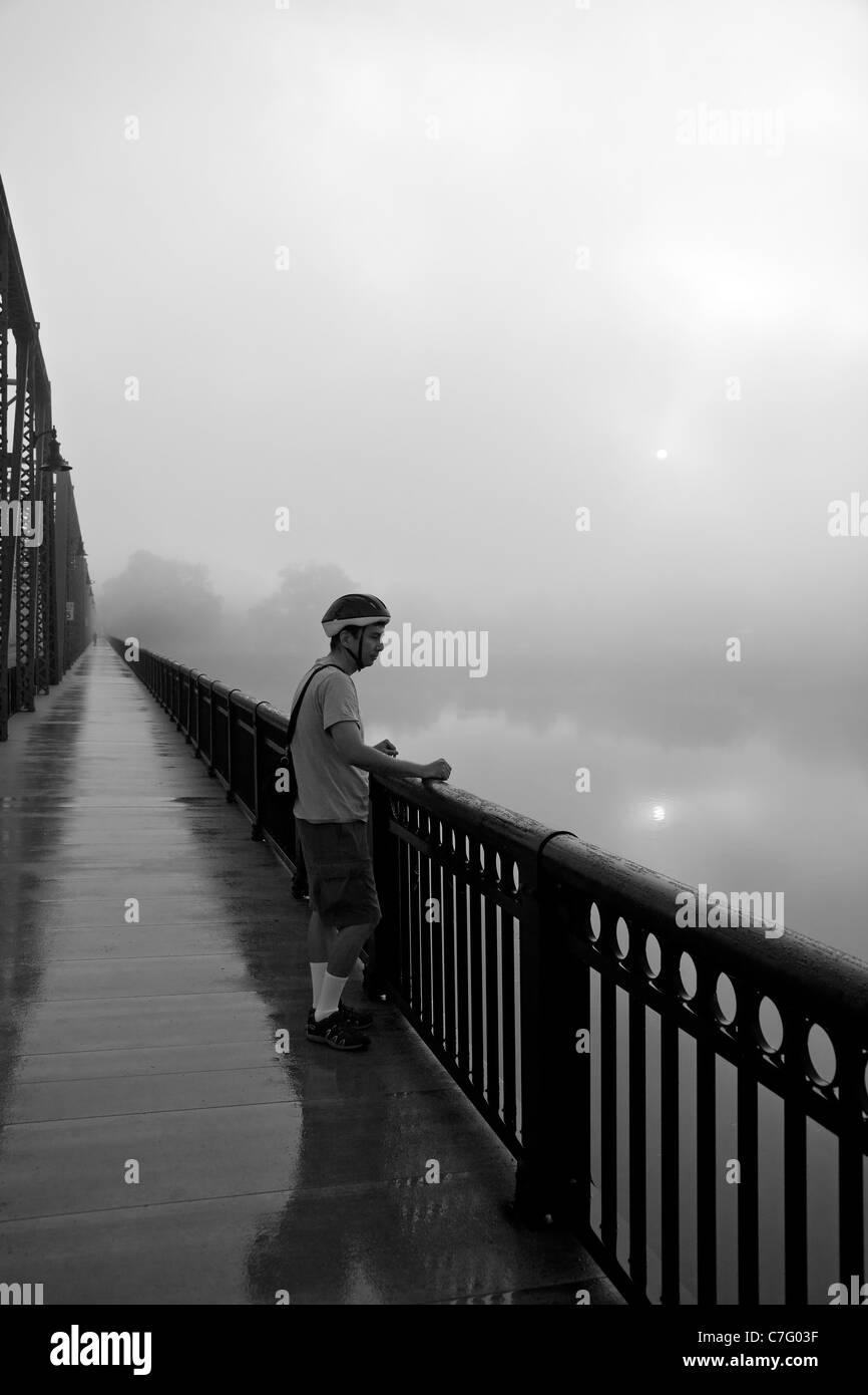 Cycliste debout sur pont sur la rivière Delaware Banque D'Images