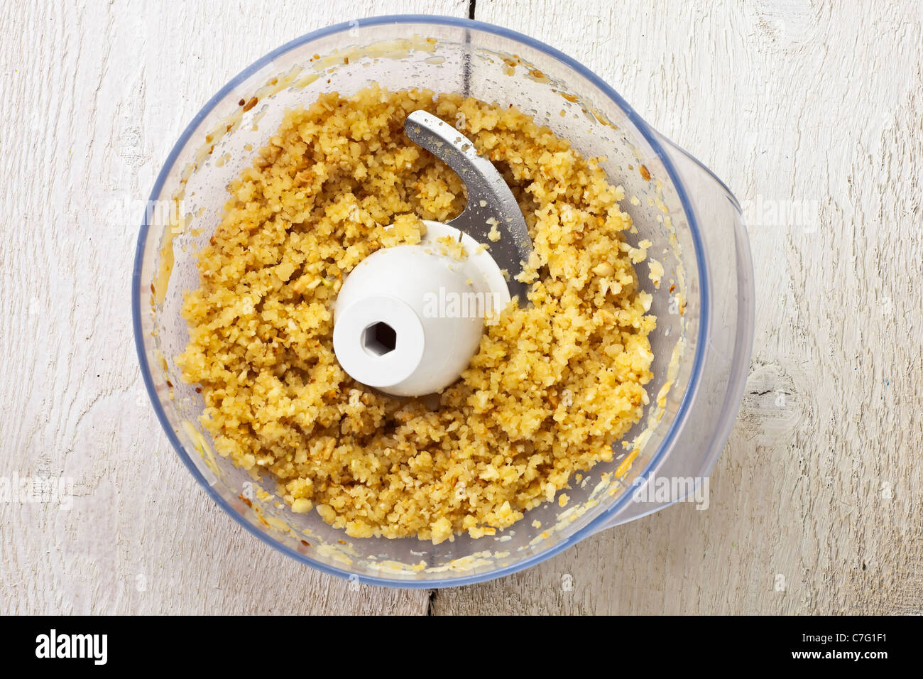 Haché Grana dans un processeur de nourriture, pecorino, pignons et l'ail pour un pesto Banque D'Images