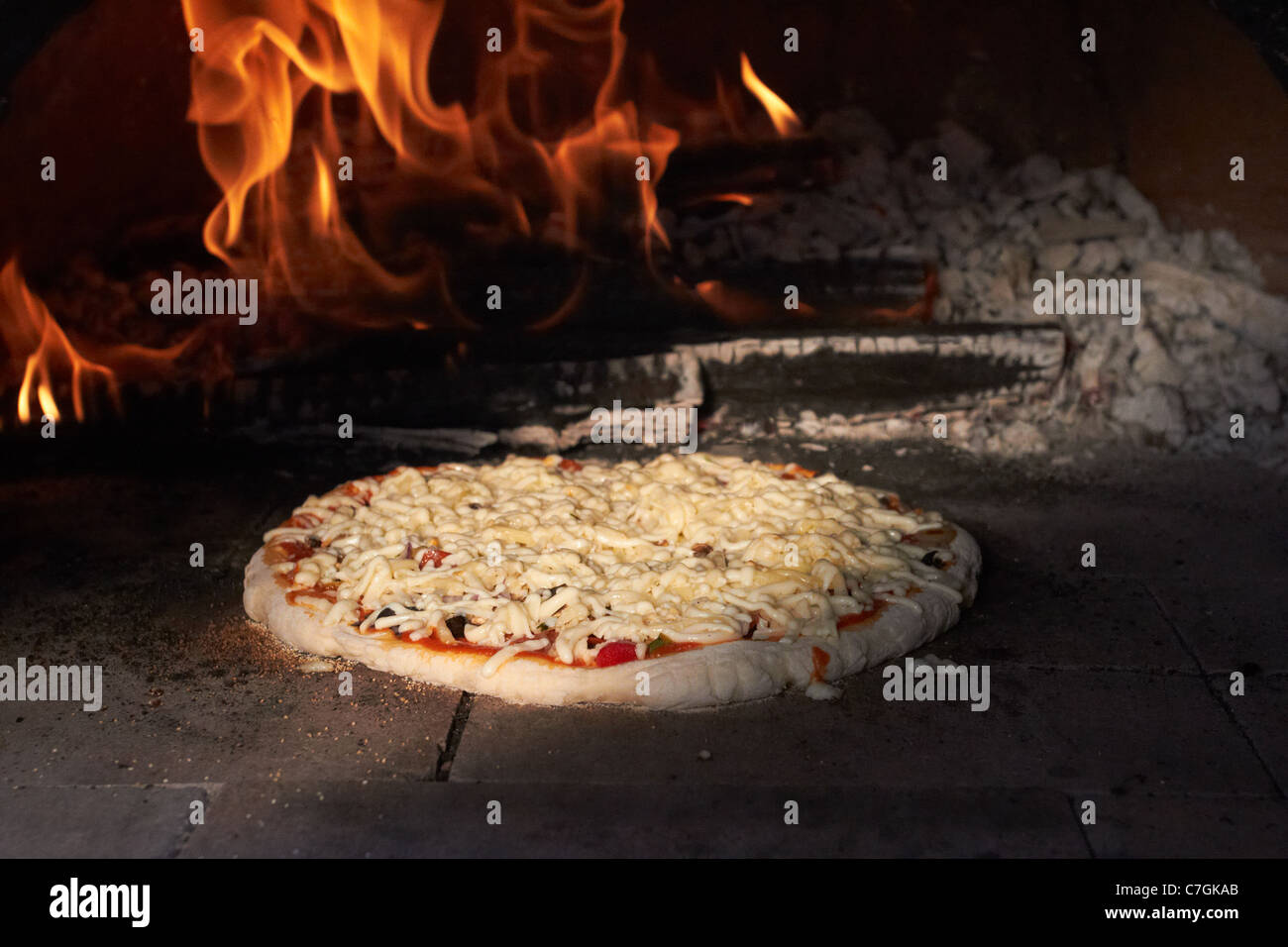 Des pizzas cuites dans un four de la Terre au feu de bois Banque D'Images