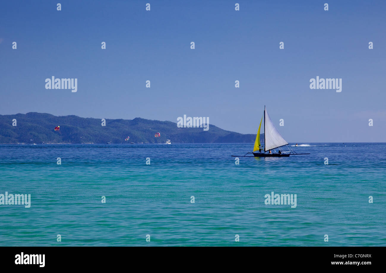 Bateau à voile jaune et blanc près de plage de sable blanc sur l'île de Boracay, Philippines. Banque D'Images