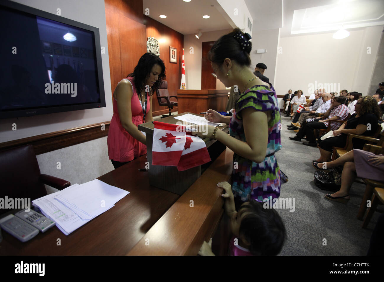 Jeune femme d'accepter la signature de documents de citoyenneté canadienne à une cérémonie de citoyenneté à Kitchener (Ontario) Banque D'Images