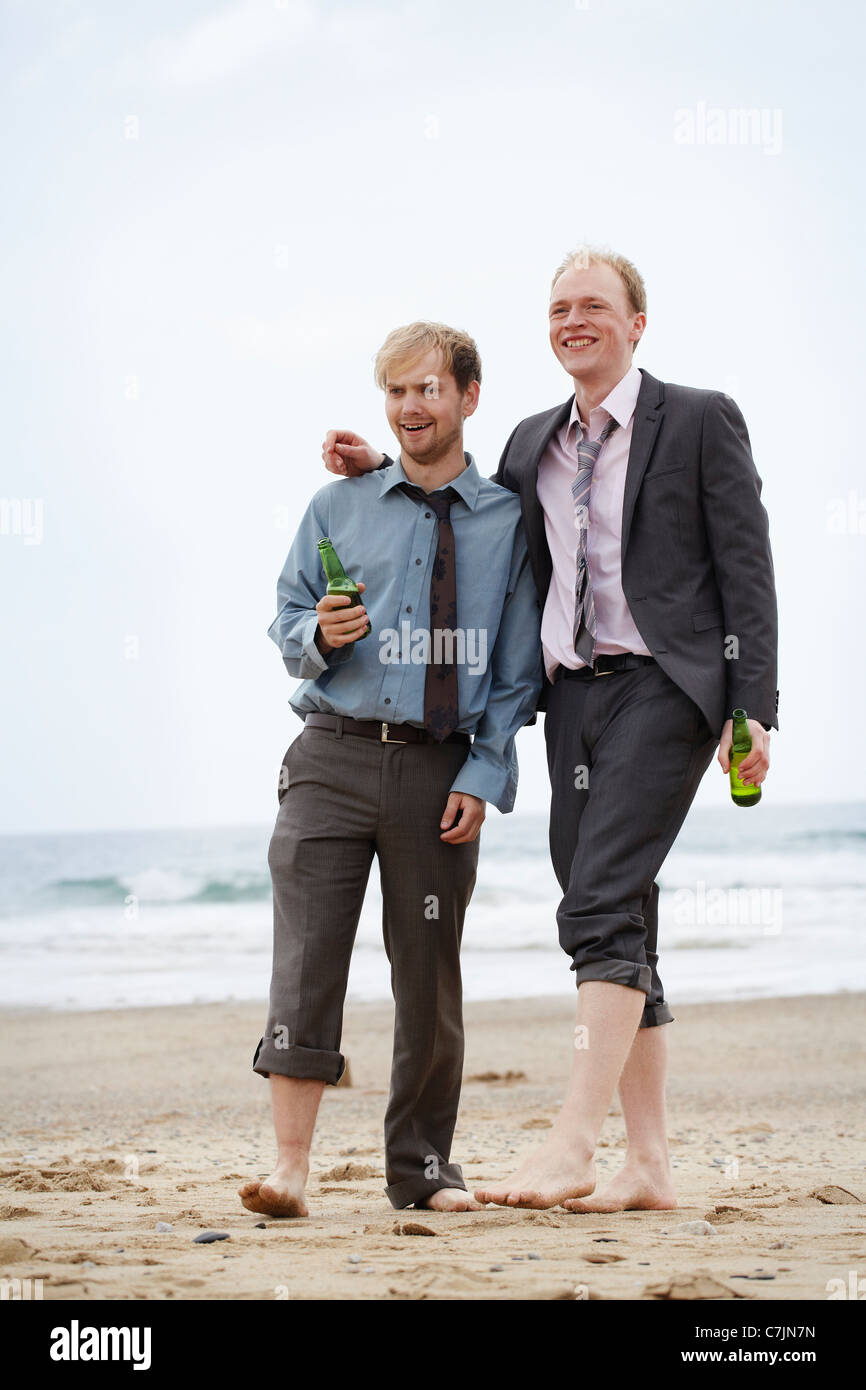 Hommes d'walking on beach Banque D'Images