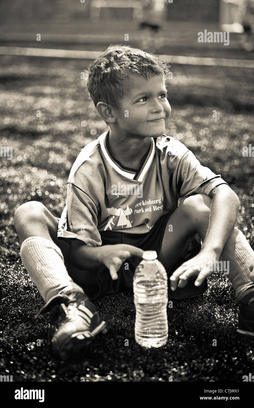 Jeune joueur de foot assis Banque D'Images