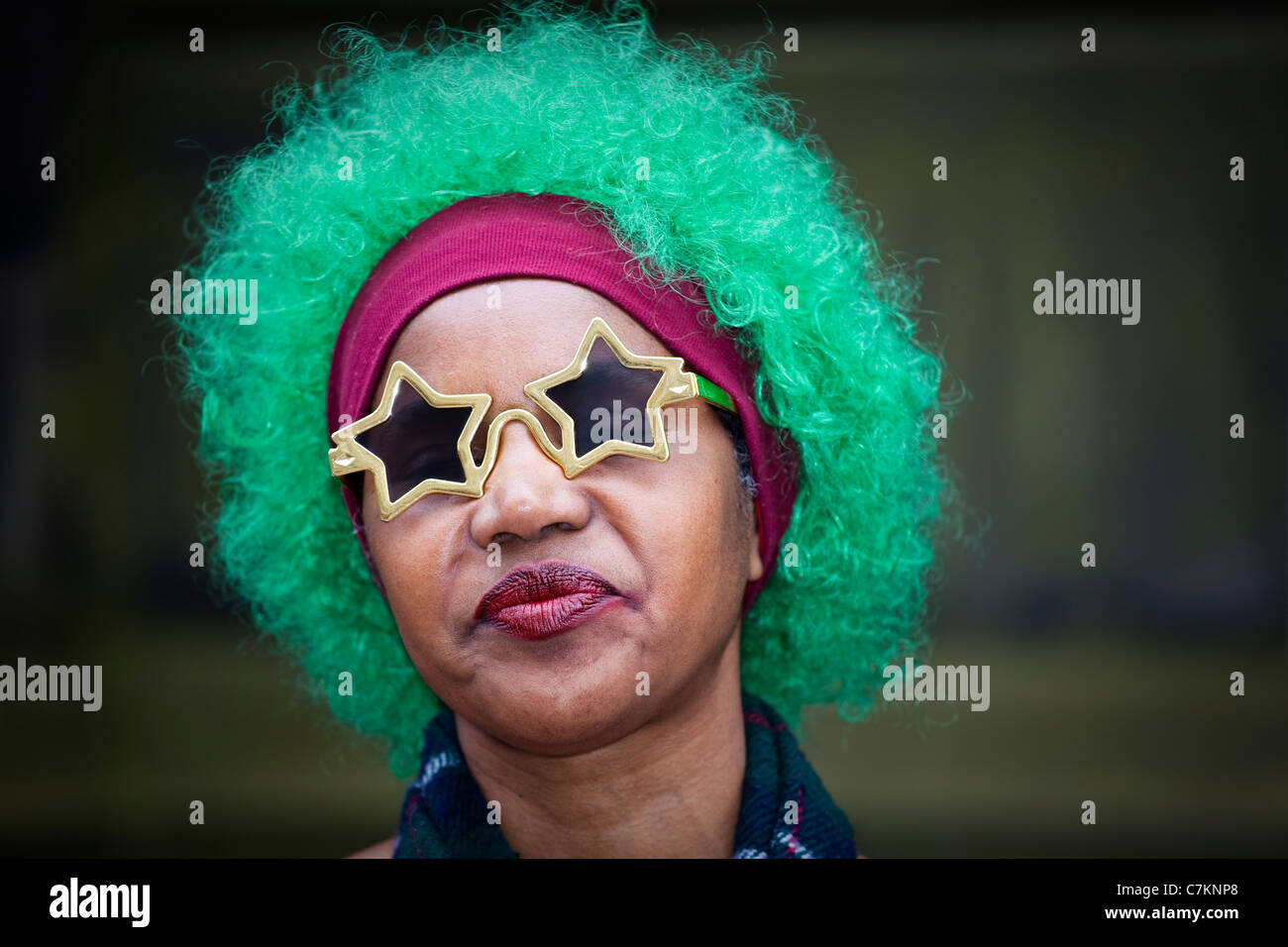 Femelle noire musicien à Edinburgh Fringe Festival, portant une perruque de couleur verte, en forme de chapeau de style star lunettes de soleil et un tartan Banque D'Images