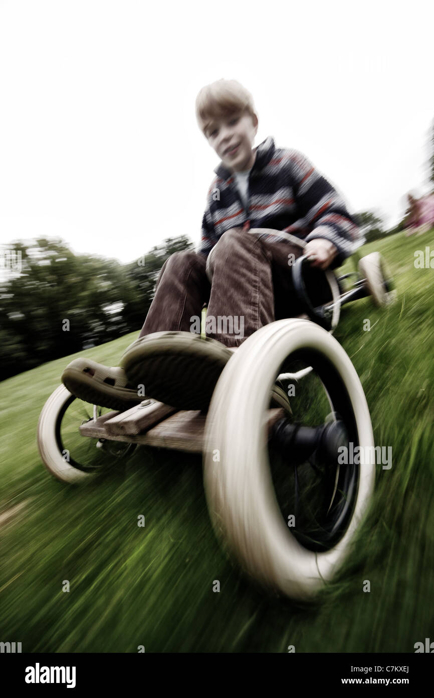 Garçon sur le kart électrique descendant grassy hill Banque D'Images