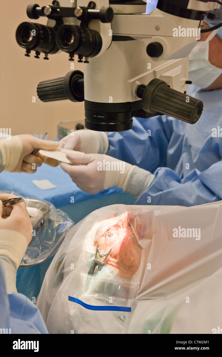 Technologue en passant à la suture chirurgicale médecin pour la chirurgie de la cataracte Banque D'Images