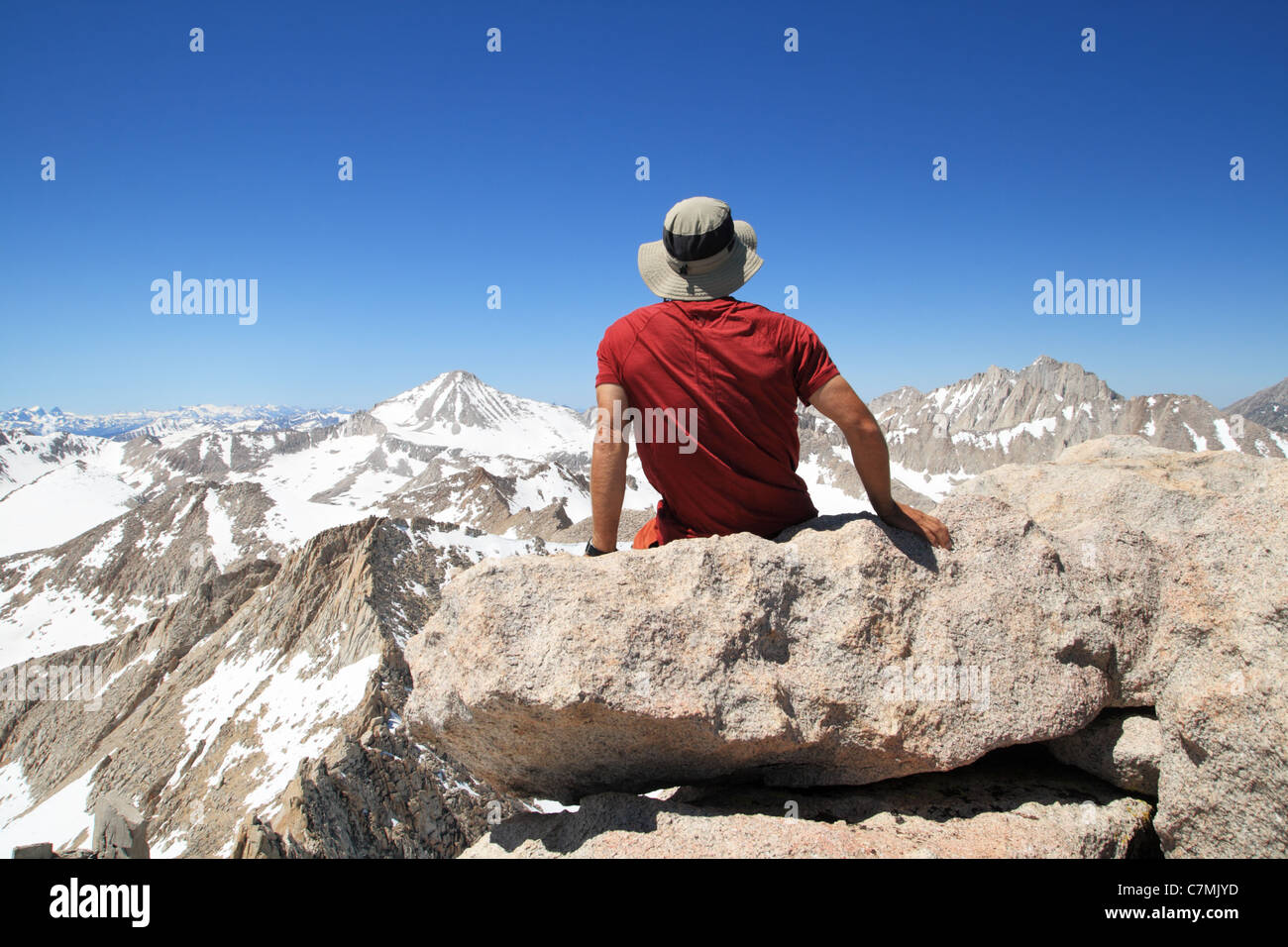 Vue arrière d'un homme assis sur le sommet de crête en plumes en profitant de la vue Banque D'Images