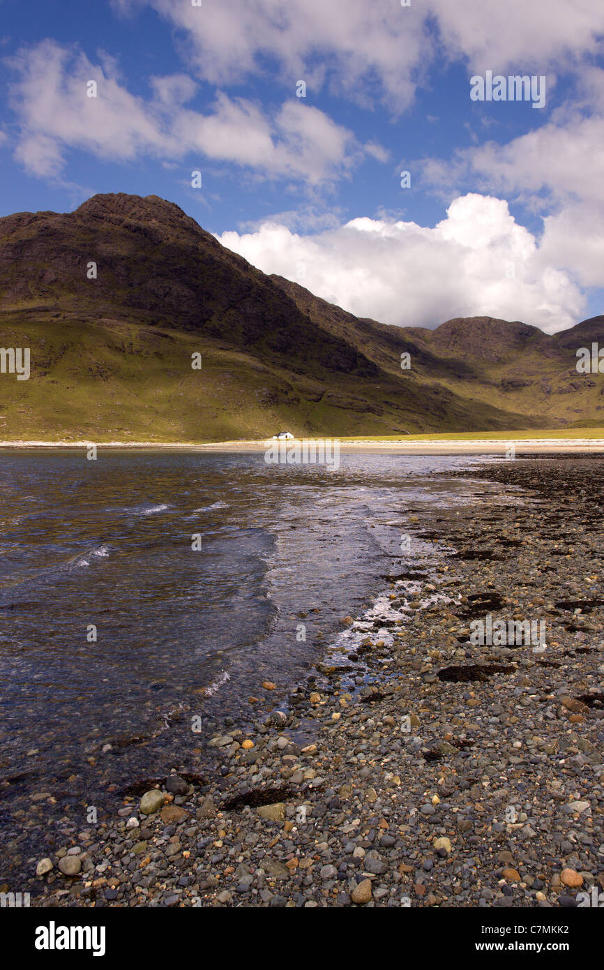 Plage à Camasunary bay avec les randonneurs isolés bothy et Black Cuillin montagnes au loin, Isle of Skye, Scotland, UK Banque D'Images