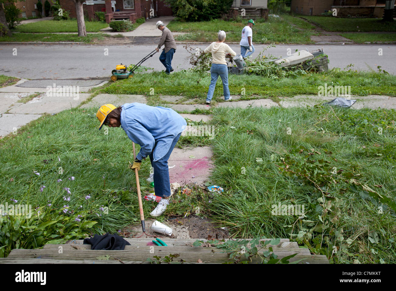 Detroit, Michigan - membres des trois Mile Drive club bloc nettoyer la corbeille et les mauvaises herbes d'une maison vacante dans leur quartier. Banque D'Images