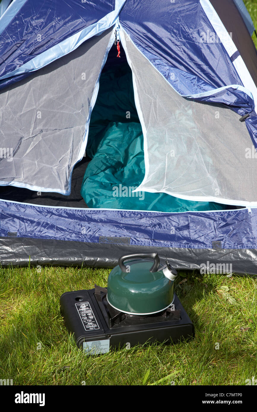L'eau bouillante dans un sifflement électrique sur un réchaud de camping  gaz devant une tente ouverte Photo Stock - Alamy