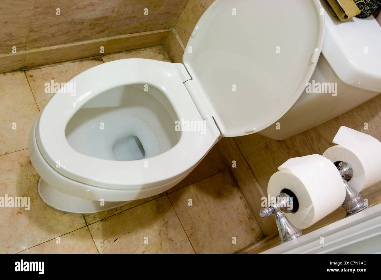 La cuvette des toilettes avec du papier par le côté d'une salle de