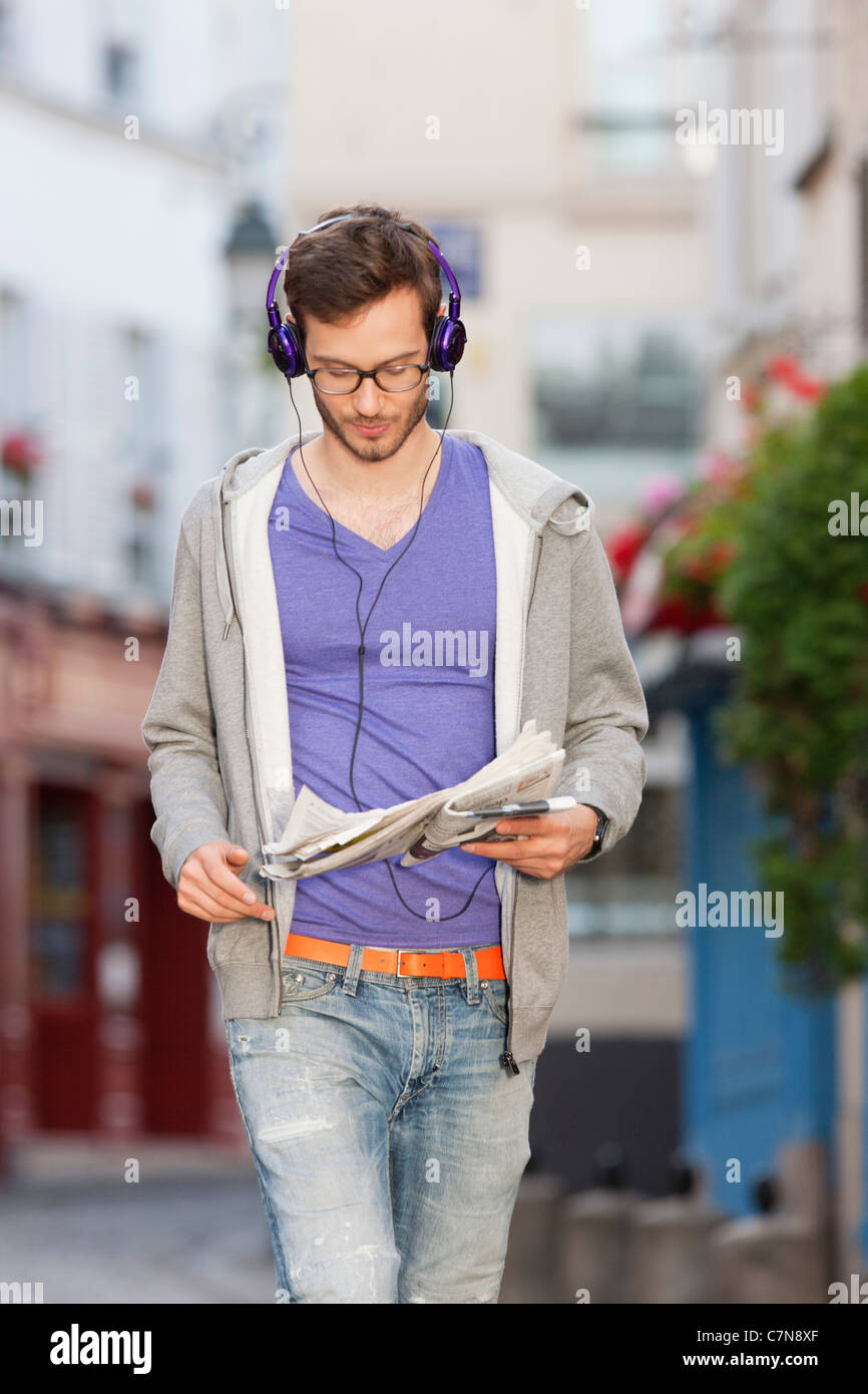 Homme lisant un journal dans la rue, Paris, Ile-de-France, France Banque D'Images