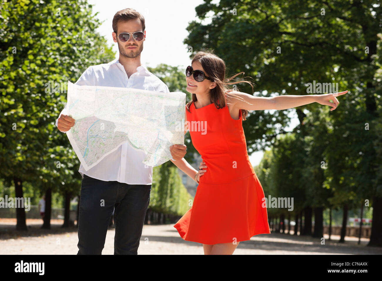 Man reading a map avec une femme qui pointe, terrasse de l'Orangerie, Jardin des Tuileries, Paris, Ile-de-France, France Banque D'Images
