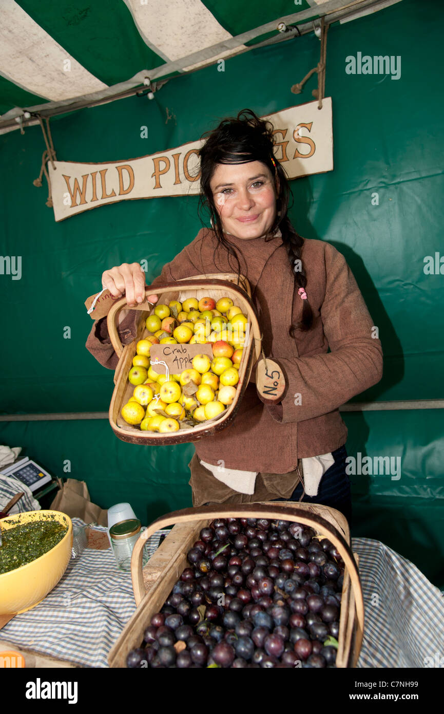 Une femme vente locale se nourrissaient des fruits sur un étal au Salon de l'alimentation, Aberystwyth, Pays de Galles, Royaume-Uni, Septembre 2011 Banque D'Images