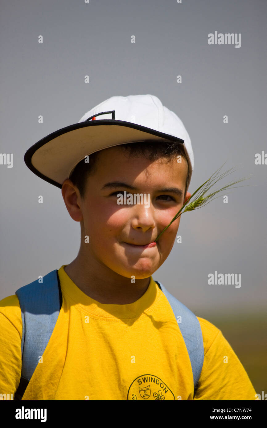 Jeune garçon avec chapeau de base-ball et de la paille Banque D'Images
