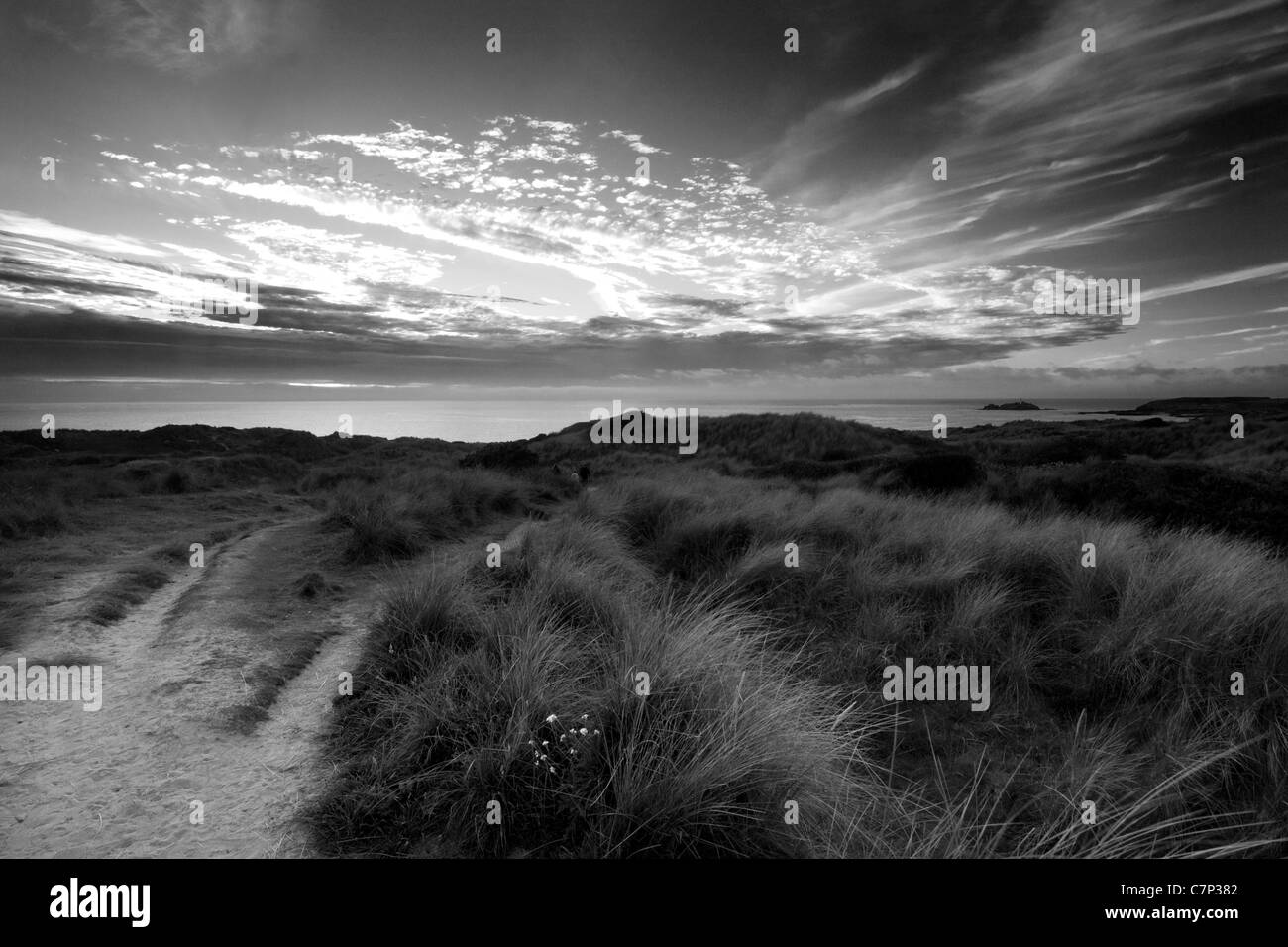 Seascape à Gwithian Cornwall sur les dunes de sable et sur la mer. Soleil du soir, coucher de soleil sur la mer. Une photographie en noir et blanc Banque D'Images