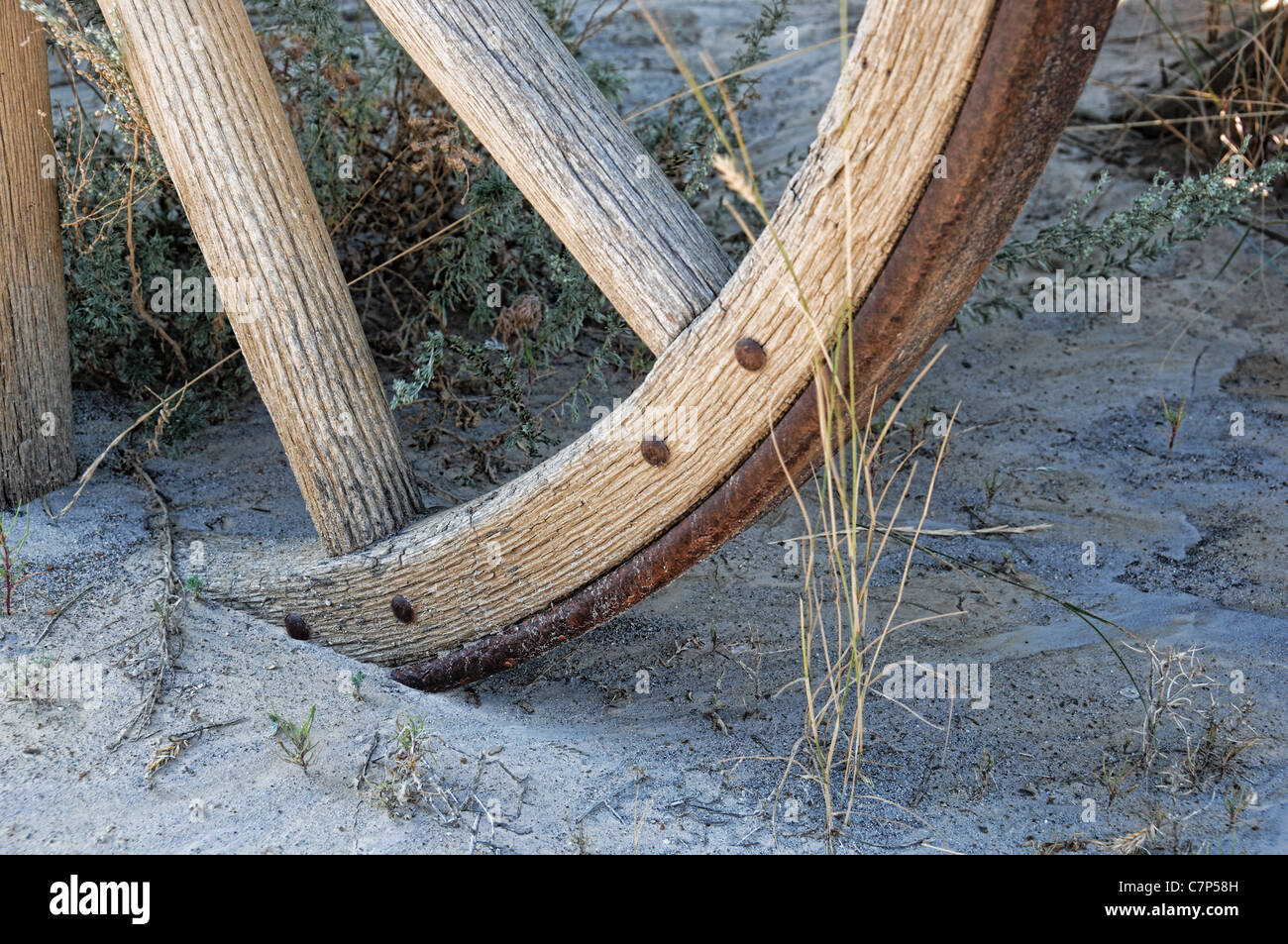Une vieille roue de chariot en bois enterré dans le sable. Banque D'Images