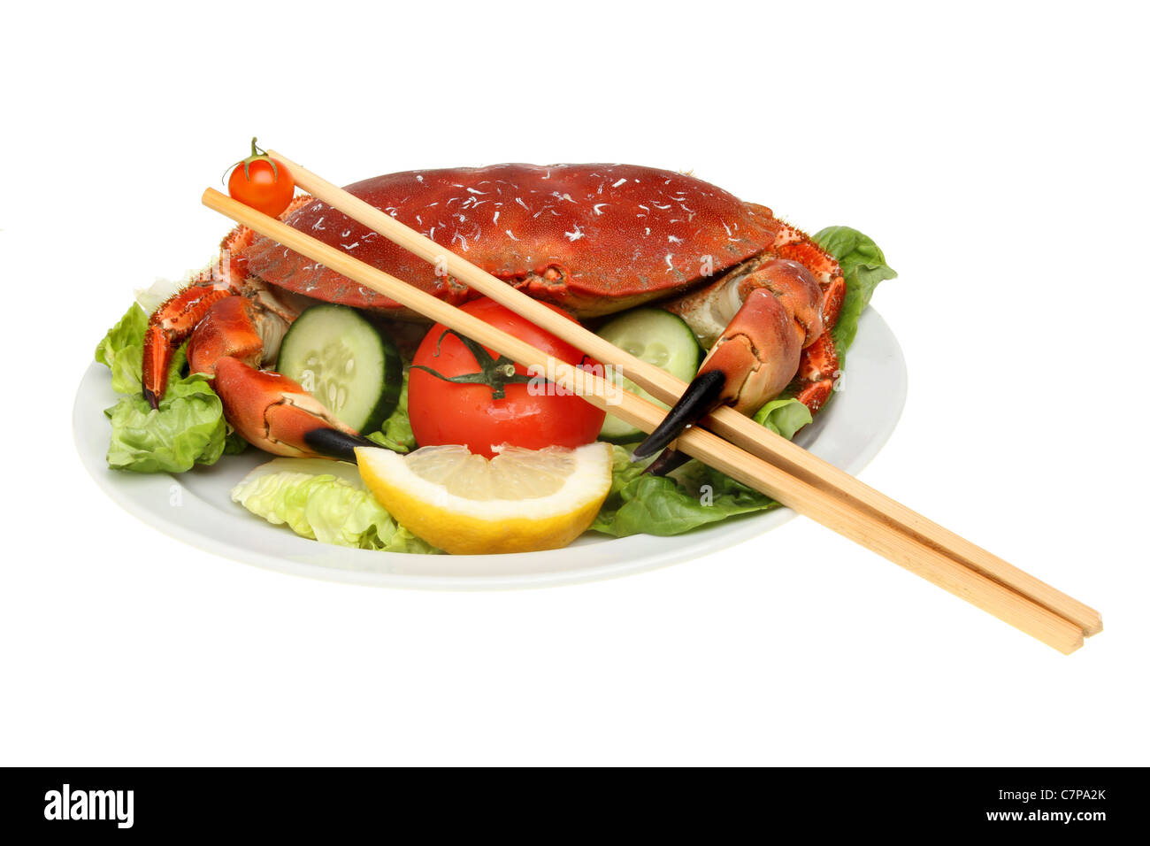 Crabe sur lit de salade avec une tomate, baguettes holding Banque D'Images