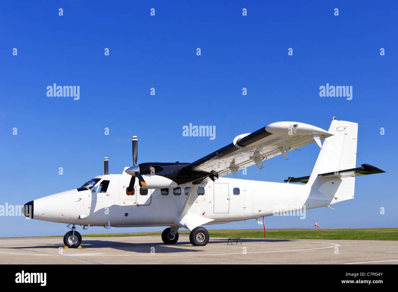 Photo d'un avion deux hélices à l'arrêt sur la piste sur une journée ensoleillée avec ciel bleu clair. Banque D'Images