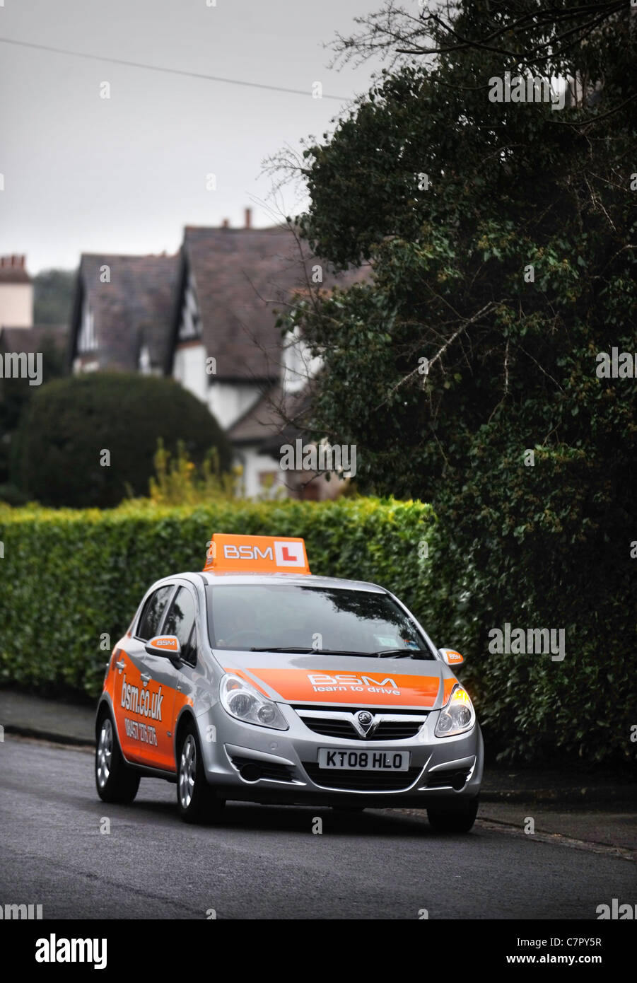 Les instructeurs de conduite BSM voiture dans une rue de banlieue typiquement en Angleterre avec une maquette caractéristique des maisons Tudor Banque D'Images