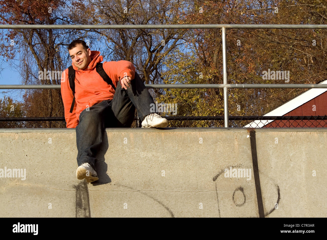 Un jeune homme posant en haut d'une rampe de skate. Banque D'Images
