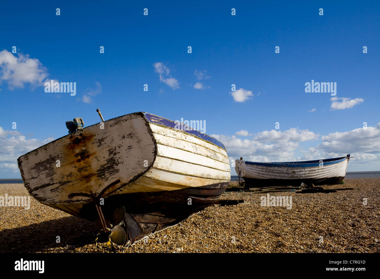 Deux vieux bateaux de pêche abandonnés sous un ciel bleu sur la plage d'Aldeburgh, dans le Suffolk, UK. Banque D'Images