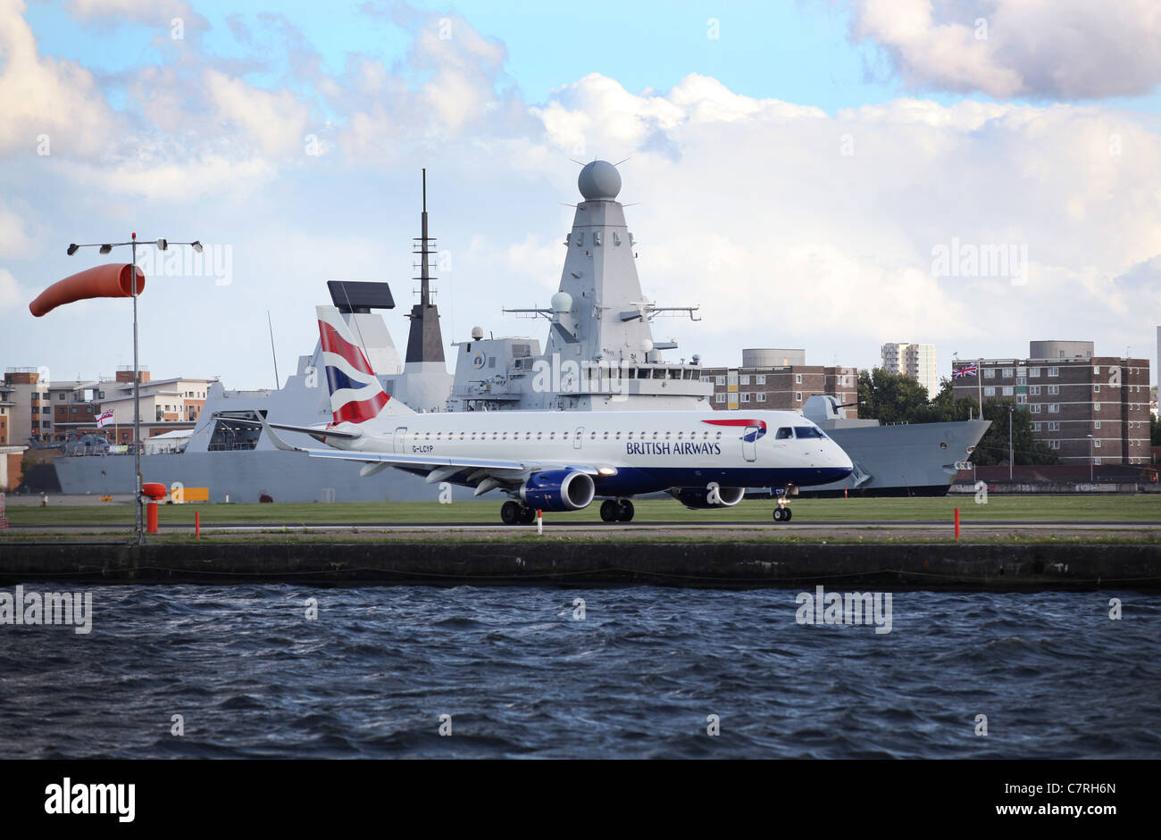 Boeing 318 de British Airways à l'aéroport de London City avec un destroyer de Type 45 de la Royal Navy dans l'arrière-plan Banque D'Images