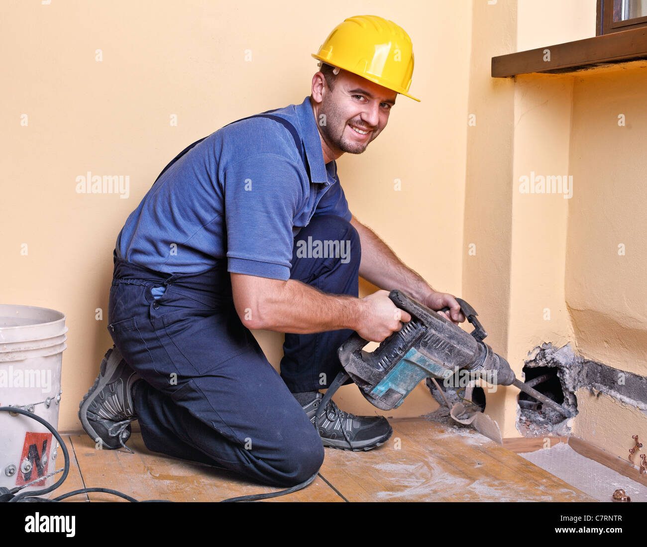 Young handyman avec big drill en service Banque D'Images